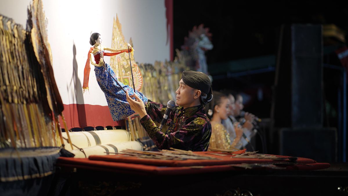 Dalang memainkan wayang kulit di atas panggung